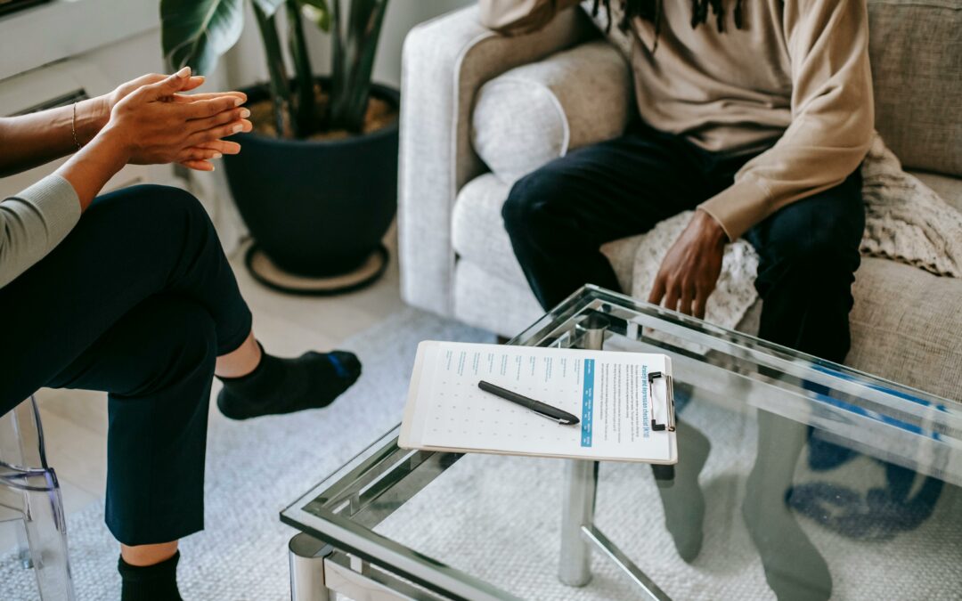 A man sitting on a couch talking to a therapist